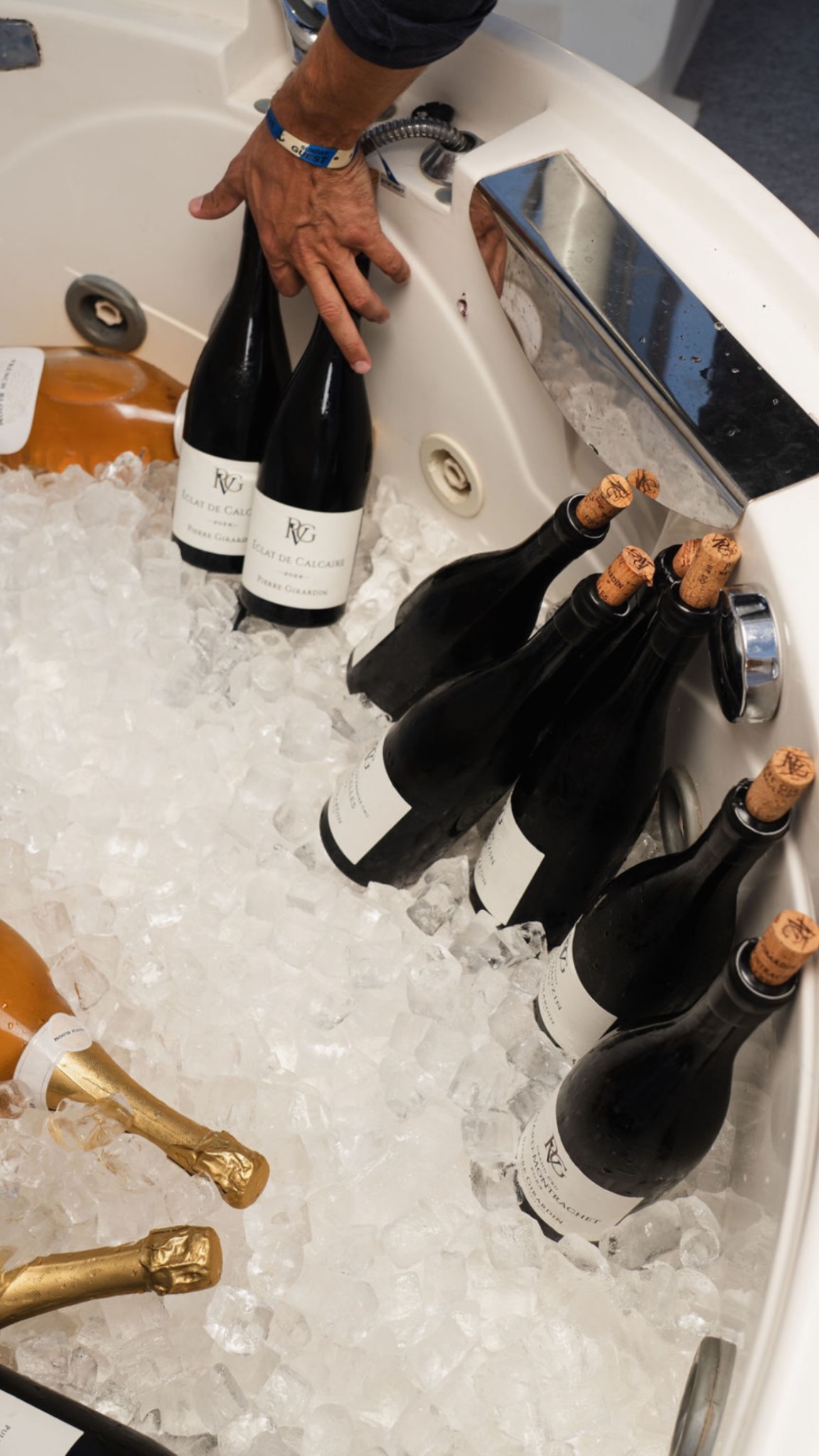 A selection of wine bottles resting on ice aboard a boat